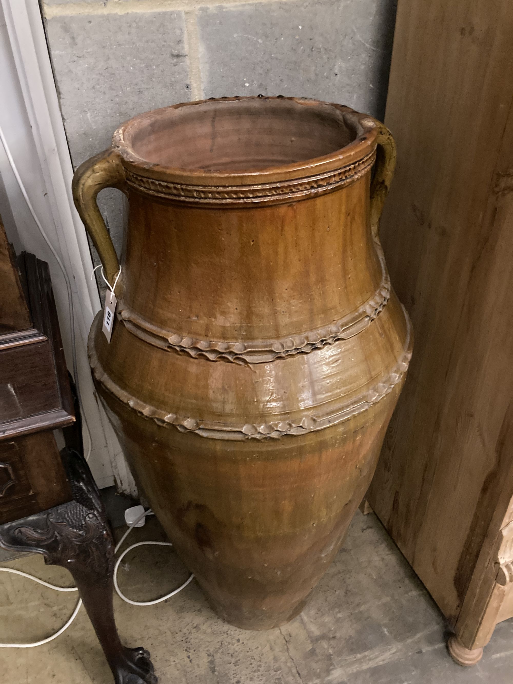 A Portuguese two-handled pottery oil jar, of waisted tapered ovoid form, height 105cm